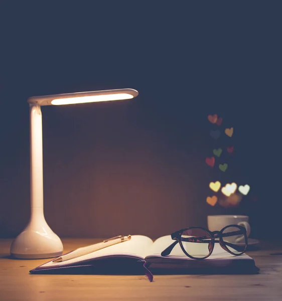 Schreibtisch mit LED-Lampe, Tasse Kaffee und Papierstapel — Stockfoto