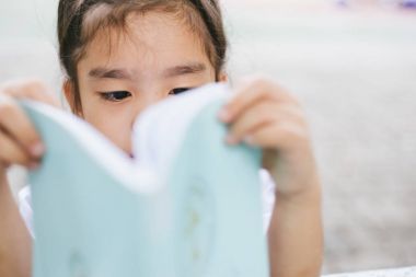 Şirin Asyalı kız okulda kitap okuma