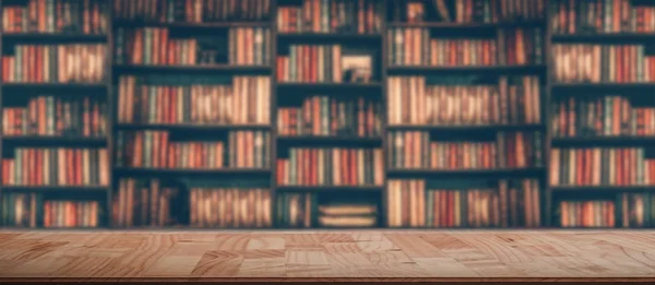 Houten tafel in wazig beeld veel oude boeken op de boekenplank in bibliotheek — Stockfoto