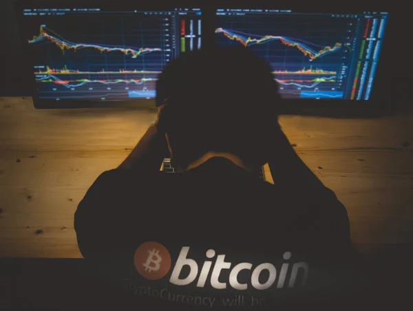 Verzweifelter Mann über den Hintergrund des Bitcoin-Kurses. — Stockfoto