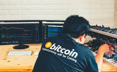 Genç bir adam bitcoin madencilik donanımını yapılandırır