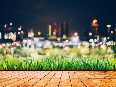 Colorful bokeh of city skyline from wood table in night time clipart