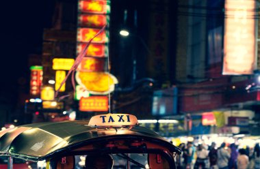 Tuk-Tuk Taxi tabelası. Ban 'daki Çin Mahallesi' nde sönmüş ışıklar bulanıklaşıyor.