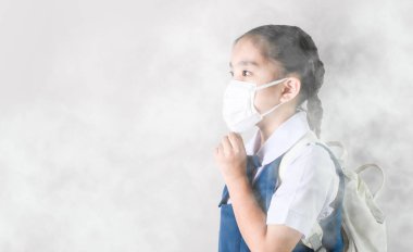 Asyalı çocukların portresi 2,5 pudrasını korumak için maske takıyor.