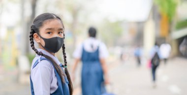 Asyalı çocukların portresi 2,5 pudrasını korumak için maske takıyor.