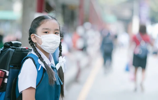 Skolflicka klädd i munnen mask mot luft smog förorening i Ban — Stockfoto