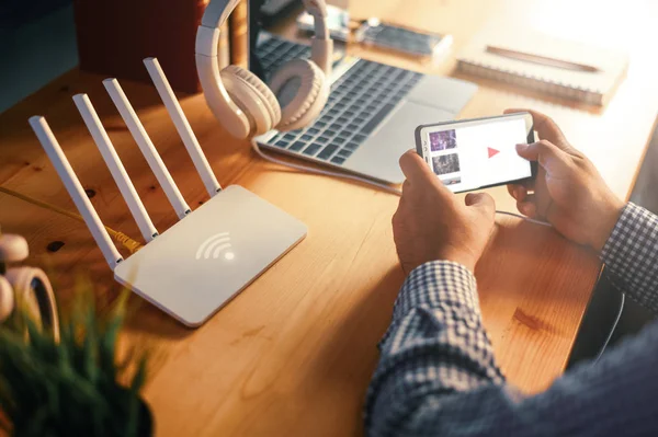 Ung man ansluta router wifi på smartphone för Internet och — Stockfoto