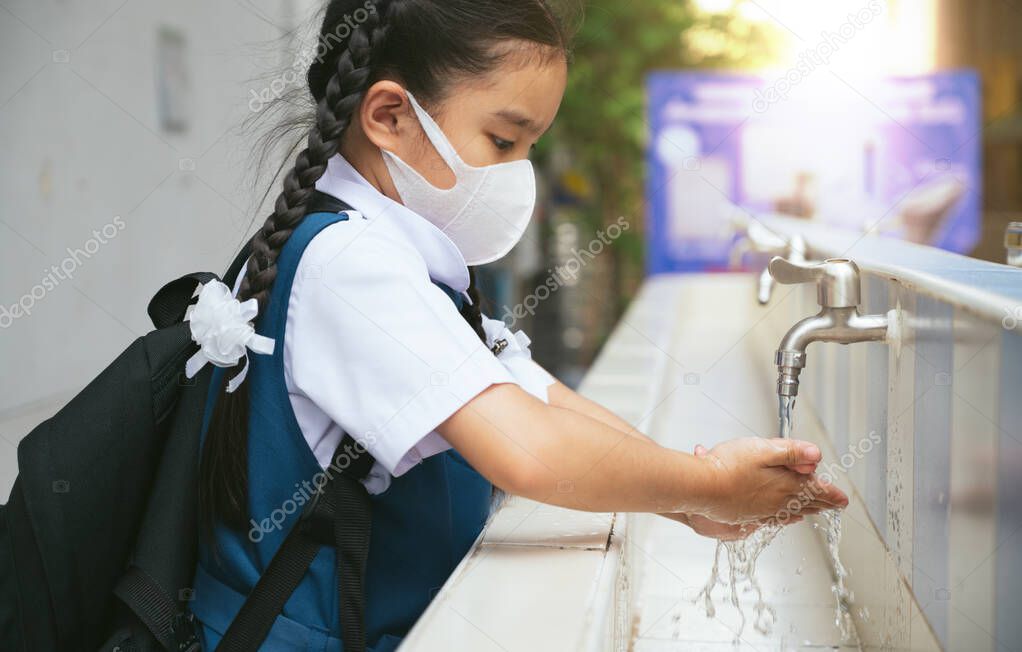 Asian student  washing hands at the outdoor wash basin in the school. Preventing Contagious diseases, Plague. Kids health, protecting the virus Covid - 19 , Saving water, Cleaning, Running water.