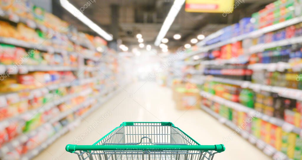 Supermarket aisle with empty green shopping cart