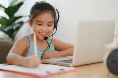 Asyalı kız öğrenci kulaklık takıyor. Webinar, konferans videosuyla iletişim kuruyor. - Evet. Evde eğitim ve uzaklık öğrenimi, online, internet koruması COVID-19 virüslerinden. 