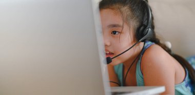Asyalı kız öğrenci kulaklık takıyor. Webinar, konferans videosuyla iletişim kuruyor. - Evet. Evde eğitim ve uzaklık öğrenimi, online, internet koruması COVID-19 virüslerinden. 