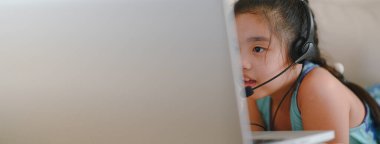 Asyalı kız öğrenci kulaklık takıyor. Webinar, konferans videosuyla iletişim kuruyor. - Evet. Evde eğitim ve uzaklık öğrenimi, online, internet koruması COVID-19 virüslerinden. 