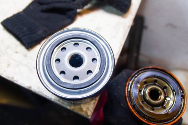 Bir araba motorunun yağ filtresini değiştirmek. yeni ve eski filtre