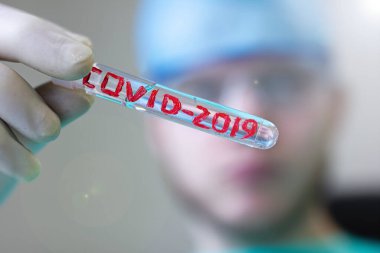 COVID-2019 Coronavirus virüsü olan tıbbi test tüpü bir doktorun elinde.