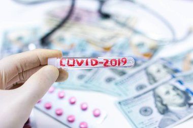 COVID 2019 Coronavirus tıbbi tüp ve dolar parası. Bir salgından kaynaklanan ekonomik felaket kavramı