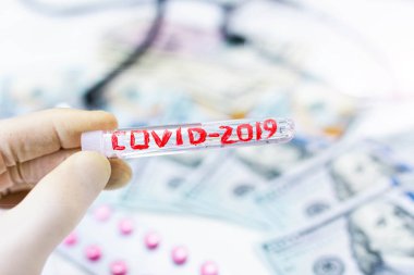 COVID 2019 Coronavirus tıbbi tüp ve dolar parası. Bir salgından kaynaklanan ekonomik felaket kavramı