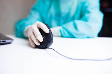 Tıbbi eldivenli bir tıp uzmanının eli dikey ergonomik bilgisayar fare joystick 'i kullanıyor. Karpal tünel sendromunu önleme