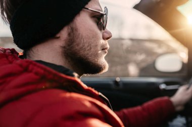 Erkek Cabriolet araba sürücüsü güneşli bir günde güneş gözlüğü takıyor..