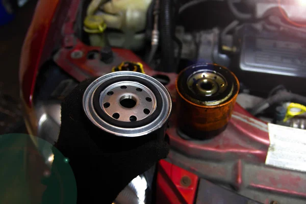 把滤油器放在汽车发动机上 新的和旧的过滤器 — 图库照片