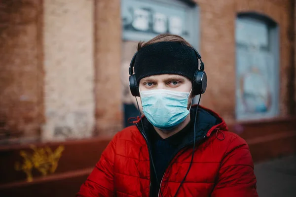 young man in a medical mask in a city during a pandemic.