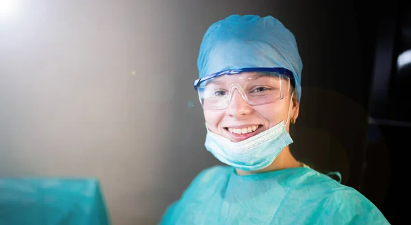 Female doctor in uniform, glasses and mask works concentrated in the hospital. portrait of a surgeon