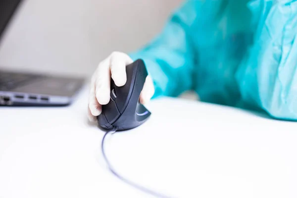 Tıbbi eldivenli bir tıp uzmanının eli dikey ergonomik bilgisayar fare joystick 'i kullanıyor. Karpal tünel sendromunu önleme