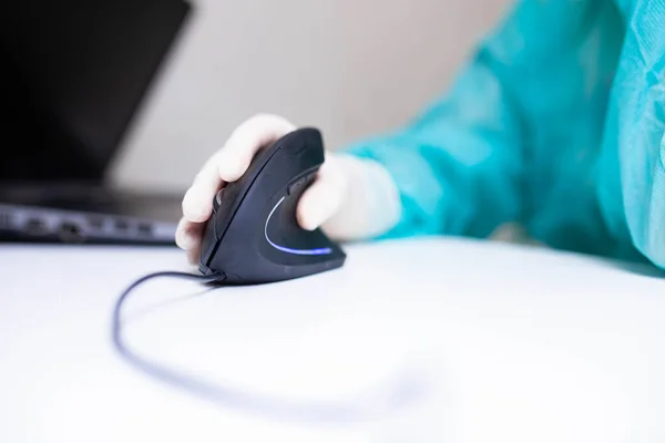 Tıbbi eldivenli bir tıp uzmanının eli dikey ergonomik bilgisayar fare joystick 'i kullanıyor. Karpal tünel sendromunu önleme