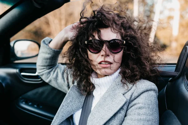 道路上の晴れた日にコンバーチブル車に乗るとサングラスで喜びで現在の女性写真家 — ストック写真