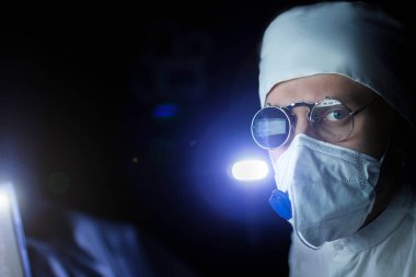 Üniformalı bilim adamı ve gözlüklü tek gözlü cam mikroskop.