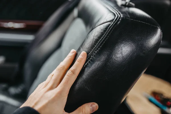 male hand on leather seat in salon of car, close view