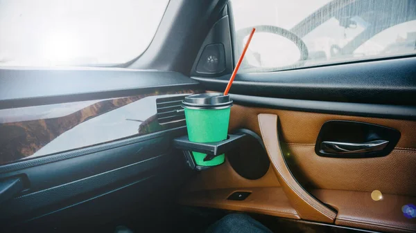 takeaway coffee cup with straw in car, close view