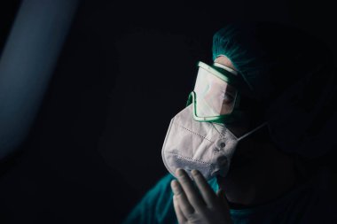 Koruyucu üniformalı bir adam ve epidemiyoloji uzmanı gözlüklü bir adam geceleri hastanede ekrana bakıyor.