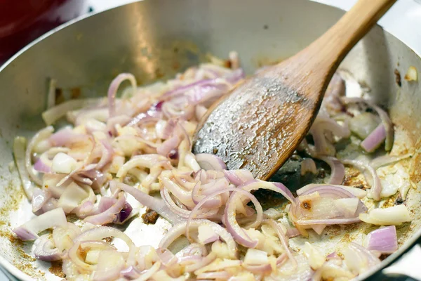 Spachtel rührt Zwiebeln in Pfanne an — Stockfoto