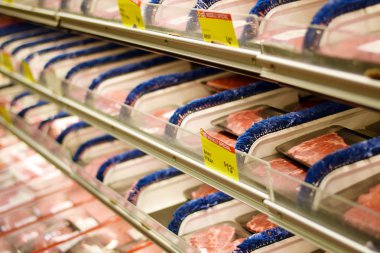 Plastik sığır eti ve domuz ürünleri bir bakkal dükkanında sarılmış.