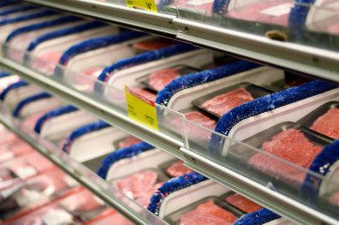 Plastik sığır eti ve domuz ürünleri bir bakkal dükkanında sarılmış.