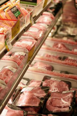 Plastik sığır eti ve domuz ürünleri bir bakkal dükkanında sarılmış.