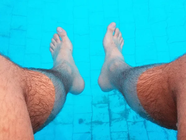 Hombre sumergiendo sus pies en una piscina — Foto de Stock