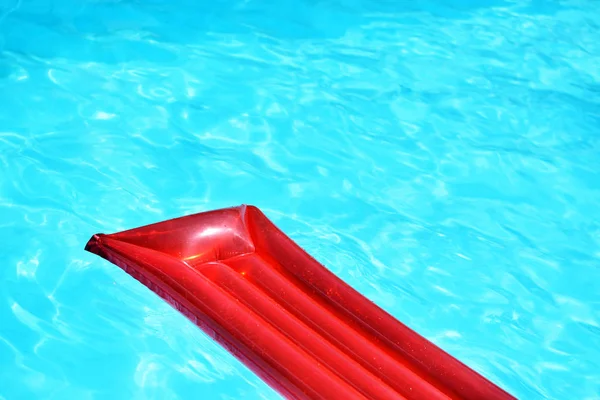 Rotes aufblasbares Pool-Floß im Pool an sonnigem Tag — Stockfoto