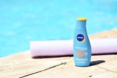 Brezilyalı Nivea güneş koruyucu bir havuzu önünde şişe