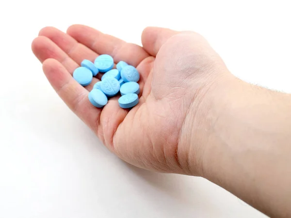Male hand holding plue pills — Stock Photo, Image