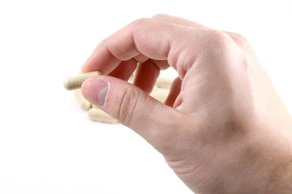 Чоловіча рука тримає бежеві таблетки з ліками в них — стокове фото