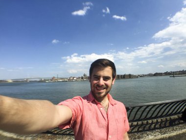 Handsome man takes selfie on sunny day clipart