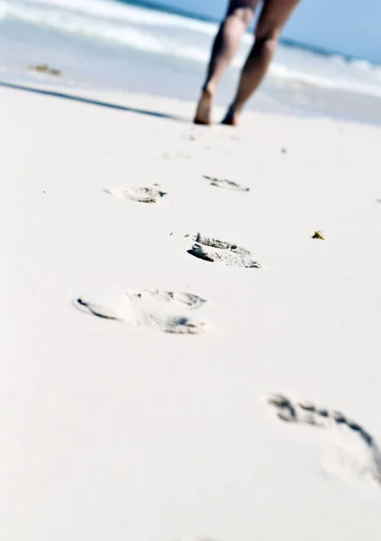 Woman\'s feet walking on sandy beach