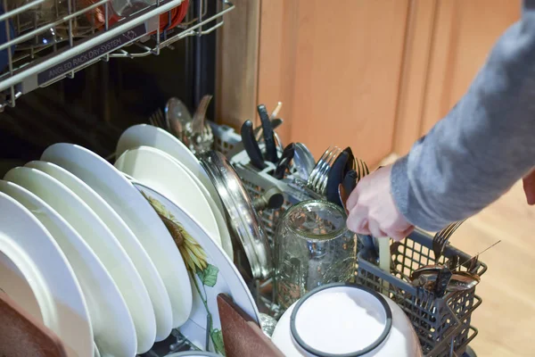Kobieta, ładowanie naczynia i sztućce do zmywarki — Zdjęcie stockowe