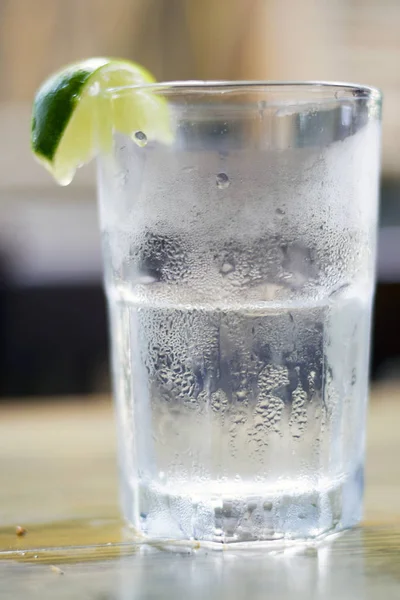 Vaso de agua con cuña de condensación y cal —  Fotos de Stock