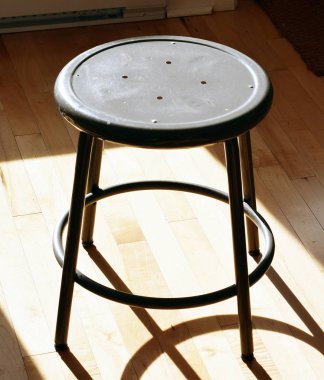 Odada ahşap zemin üzerinde metal tabure