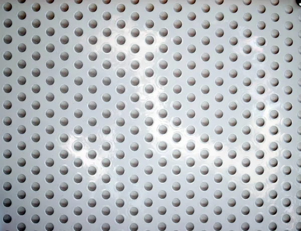 Superficie metálica blanca con agujeros redondos — Foto de Stock