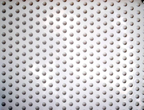 Белая металлическая поверхность с круглыми отверстиями — стоковое фото