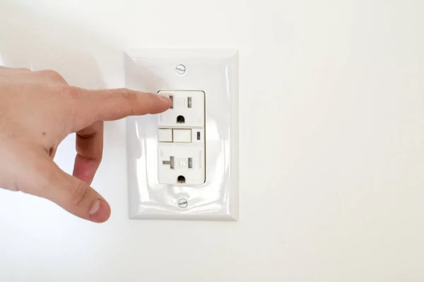 Finger dangerously close to electrical socket Stock Image