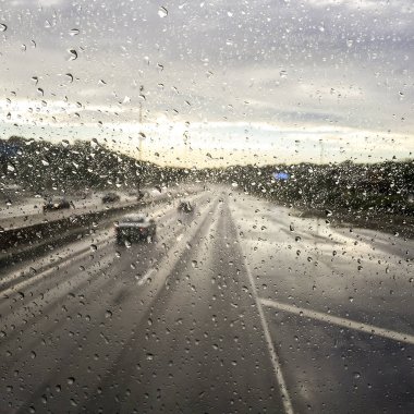 Yağmur su damlacıkları bir araba pencere ile otoban düşürüyorlardı üzerinde bulanıklık